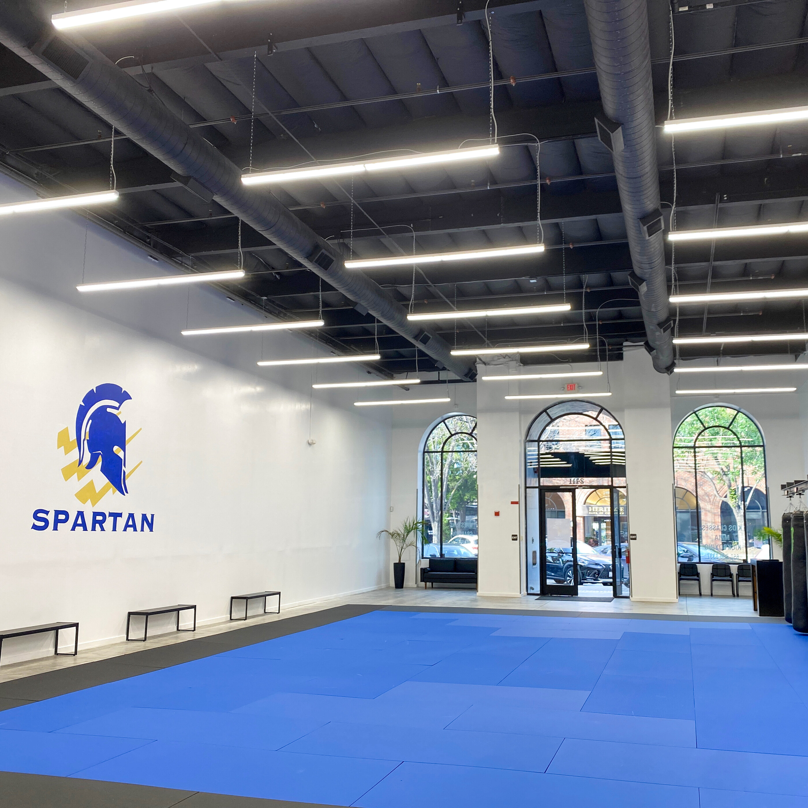 Training floor and heavy bags inside Spartan Combat Sports